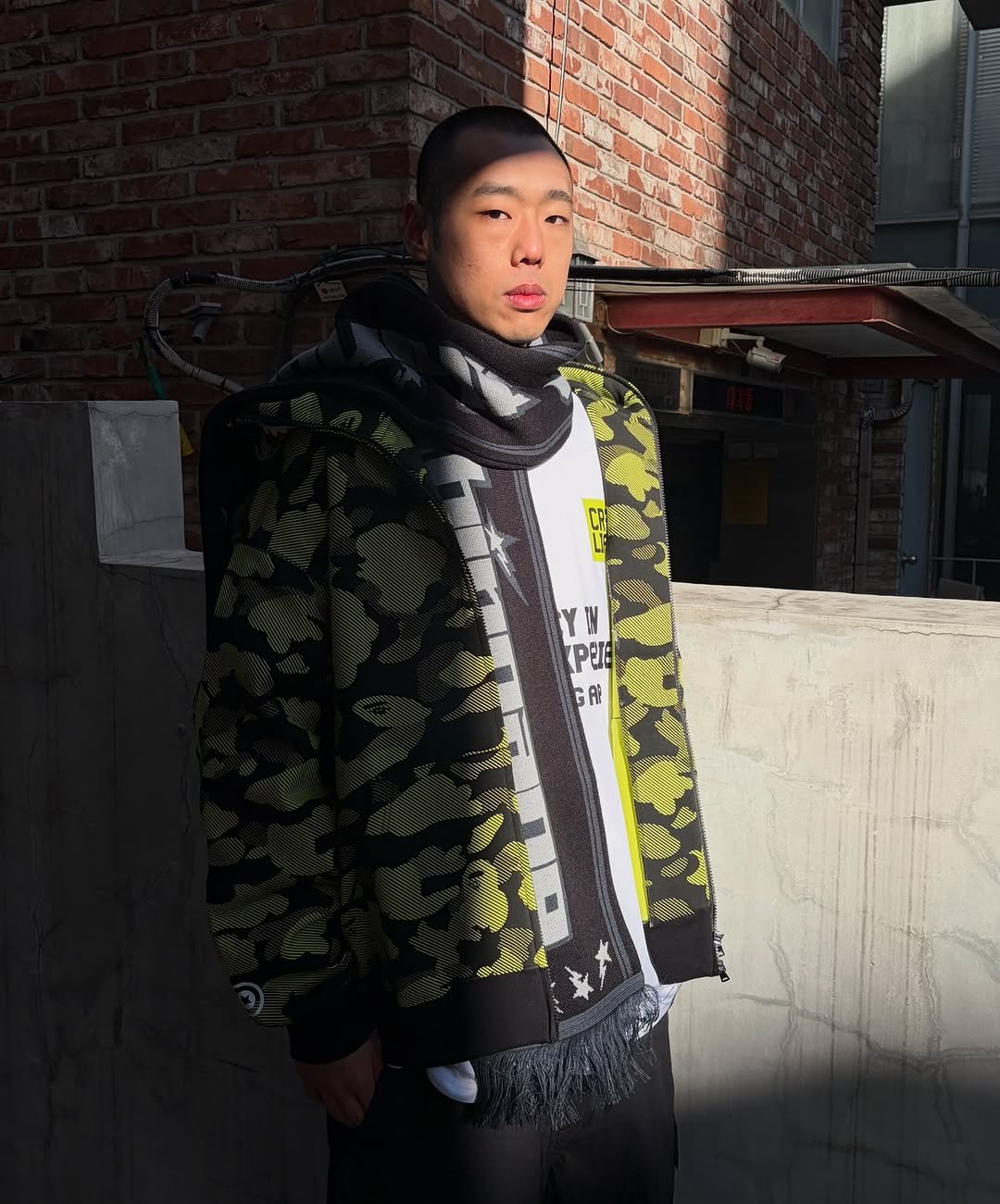 Photo shared by BAPE SEOUL on January 13, 2026 tagging @bapestorekorea, and @bape_seoul. May be an image of one or more people, duffle coat, face mask, shawl, sweater, bandanna, scarf, parka, turtleneck and text.