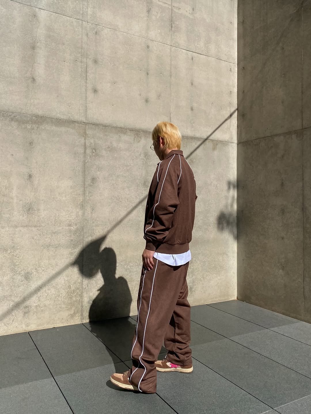 Photo shared by BAPE SEOUL on November 09, 2025 tagging @bapestorekorea, and @bape_seoul. May be an image of standing, sweatsuit, sweatpants and text.