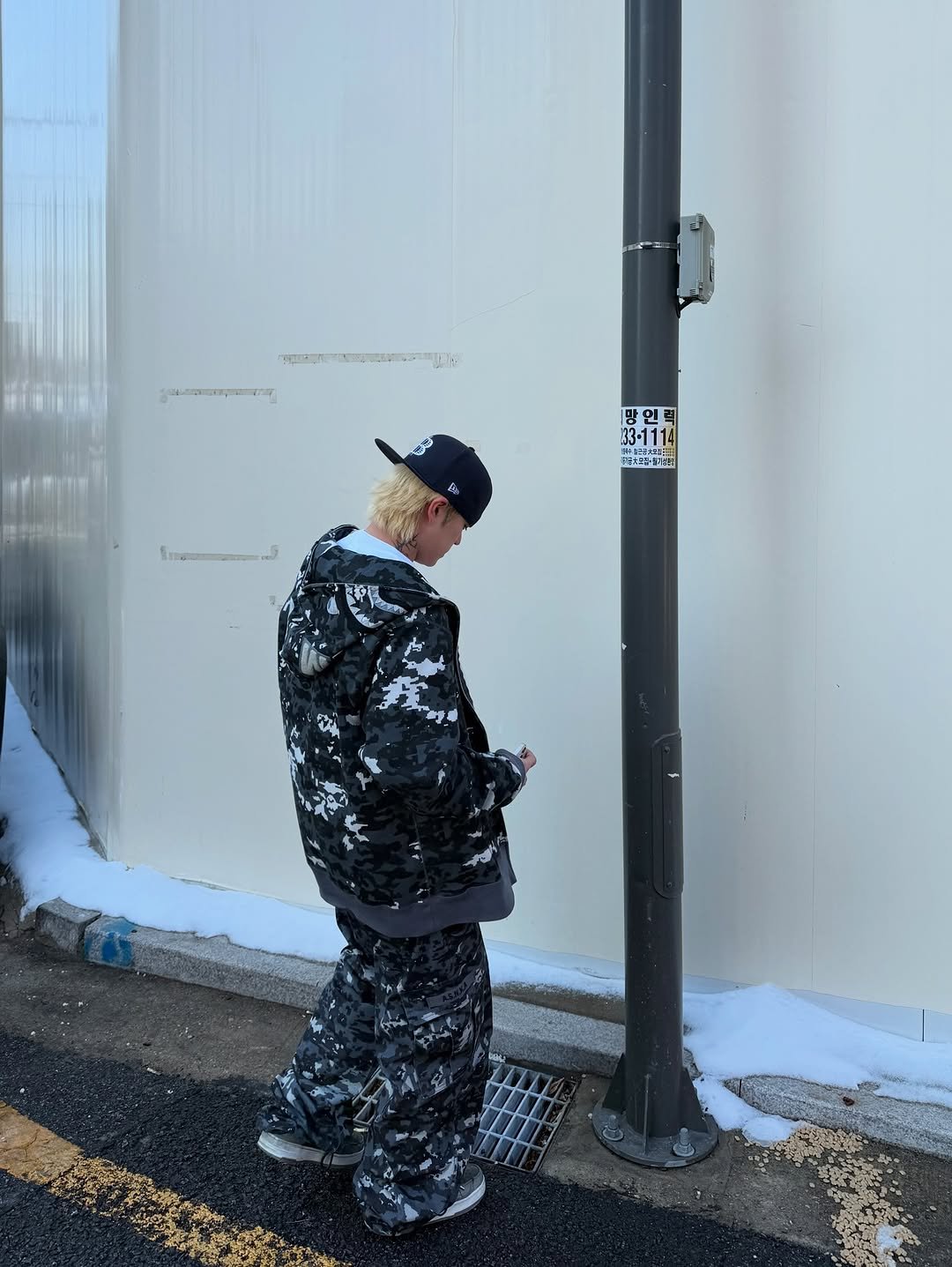Photo shared by BAPE SEOUL on March 02, 2026 tagging @bapestorekorea, and @bape_seoul. May be an image of standing, parking meter, parka, sweatpants, pole, street, telephone pole, lamppost and text.