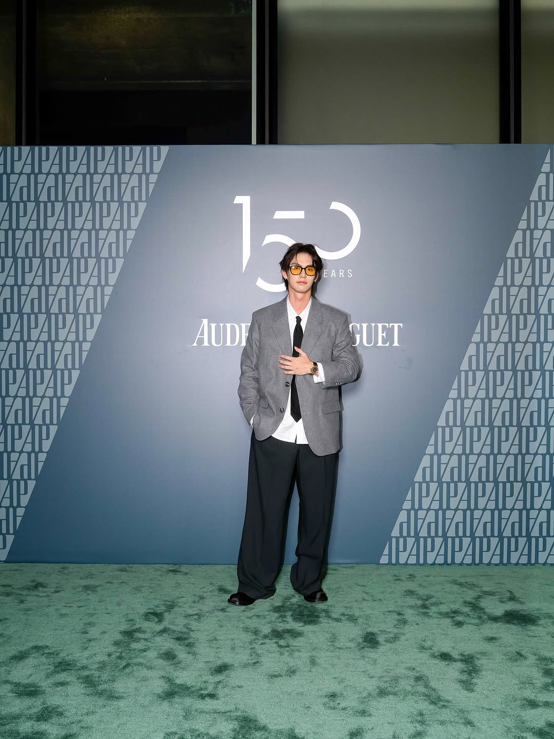 Photo shared by BRIGHT on September 12, 2025 tagging @audemarspiguet. May be an image of 1 person, standing, suit, carpet, dinner jacket and text.