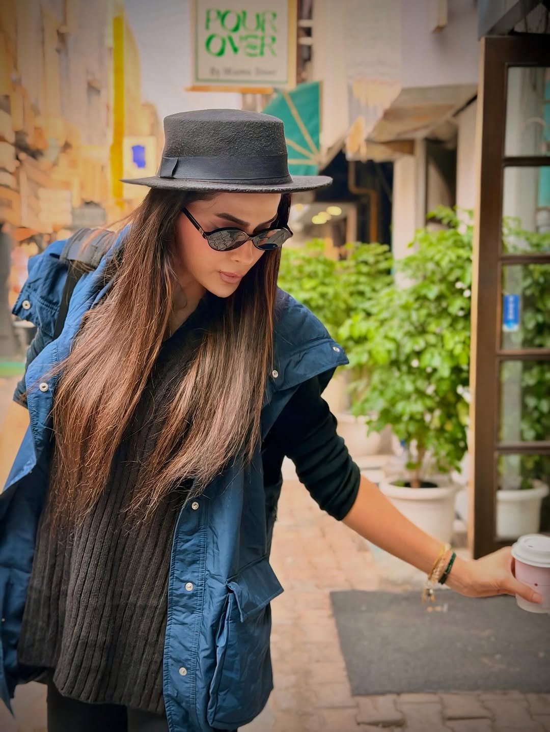 Photo by Bhavana Singh on November 27, 2025. May be an image of eyewear, hat, jacket, beret, bowler hat, parka, street and text.