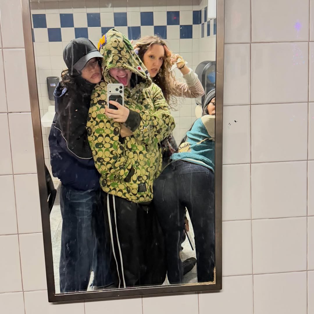 Photo shared by BILLIE EILISH on December 23, 2025 tagging @sydn4sty, @quenblackwell, and @odessaazion. May be a selfie of phone, mirror, parka, sweatpants and text.