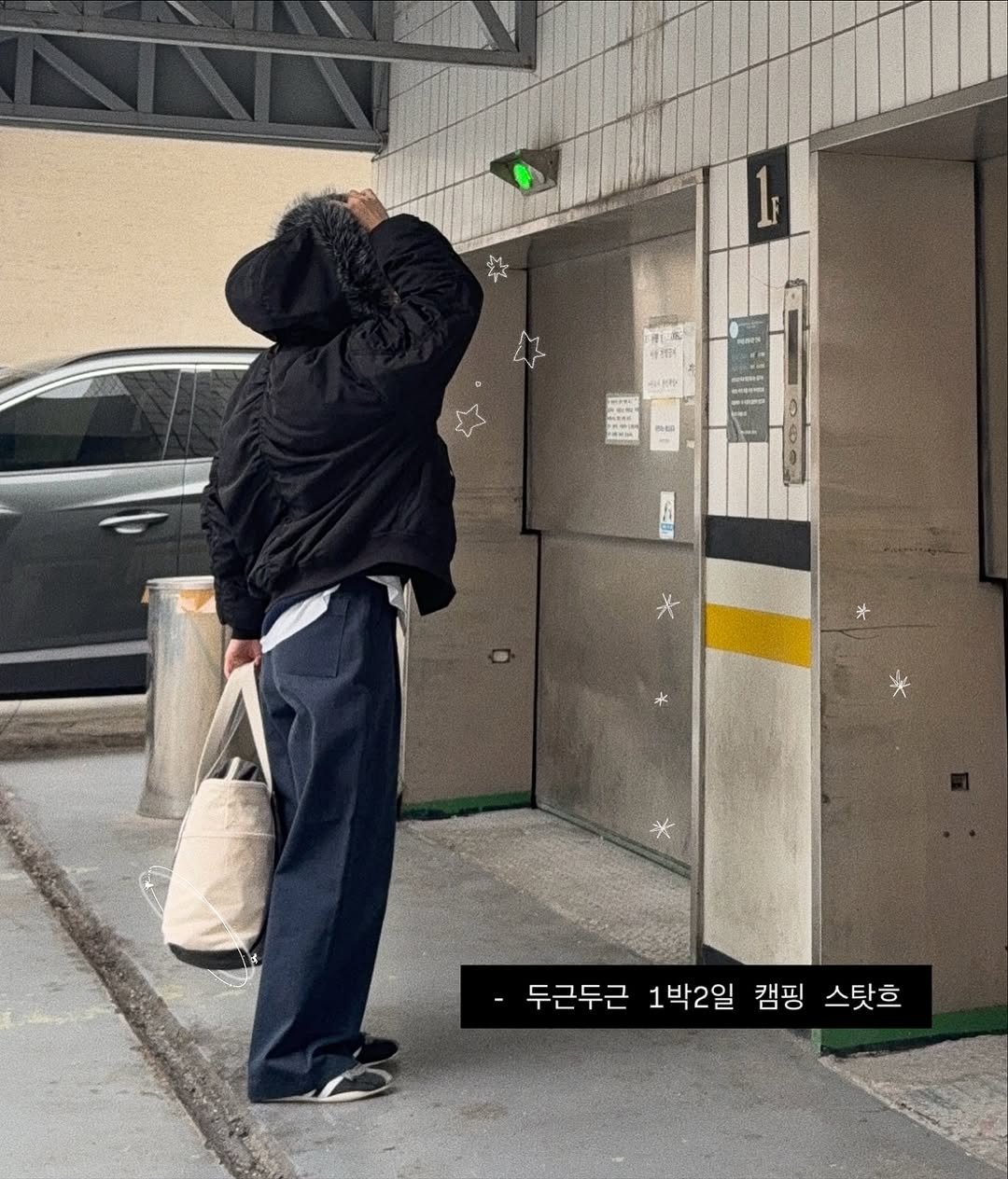 Photo by 현뱌 on November 12, 2025. May be an image of one or more people, people standing, duffle coat, overcoat, parking meter, cigarette, street and text that says '智究 수크 * 두근두근 1박2일 캠핑 -두근두근1박2일캠핑스릿흐 스탓흐'.