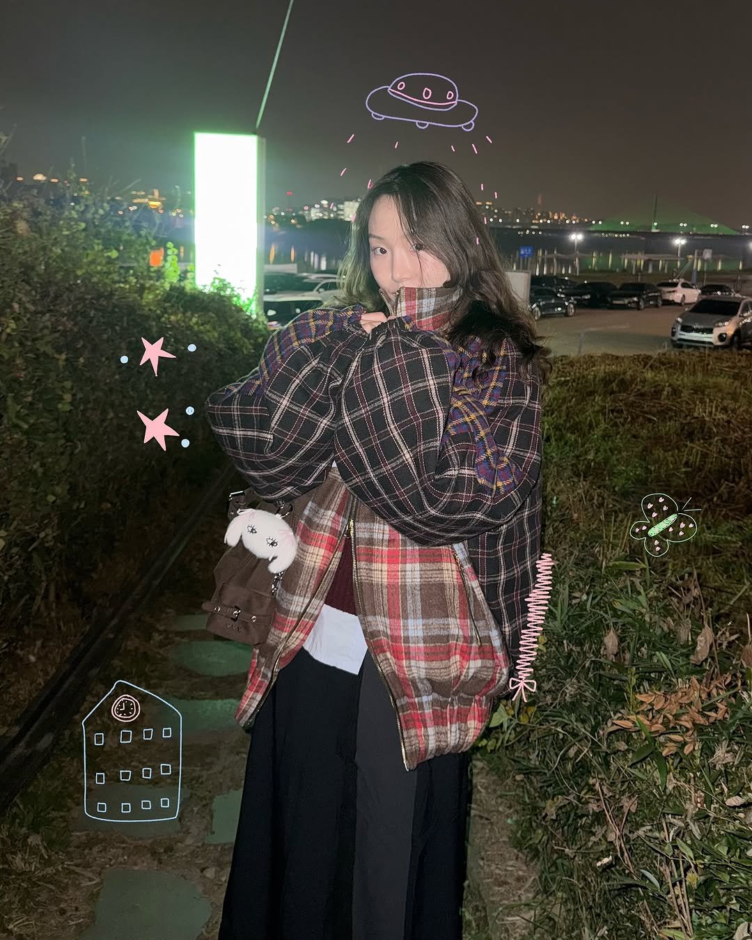 Photo by 현뱌 on November 07, 2025. May be an image of one or more people, hair, duffle coat, overcoat, parka, cloak, night and text.