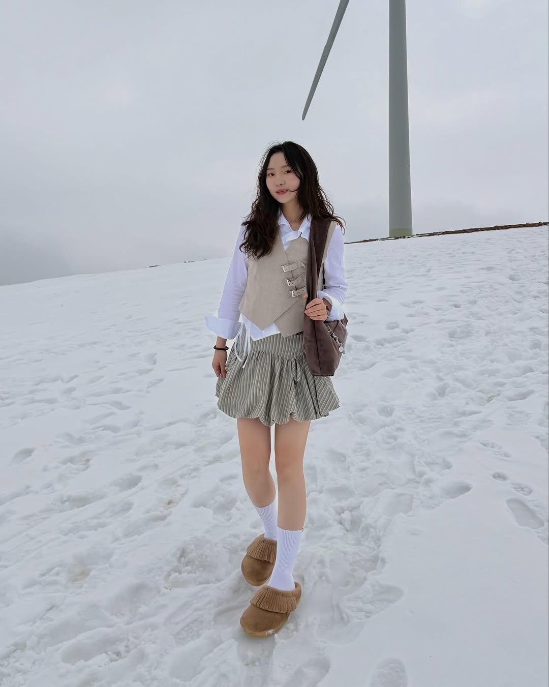 Photo by 현뱌 on March 18, 2026. May be an image of miniskirt, parka, windmill, snow and text.