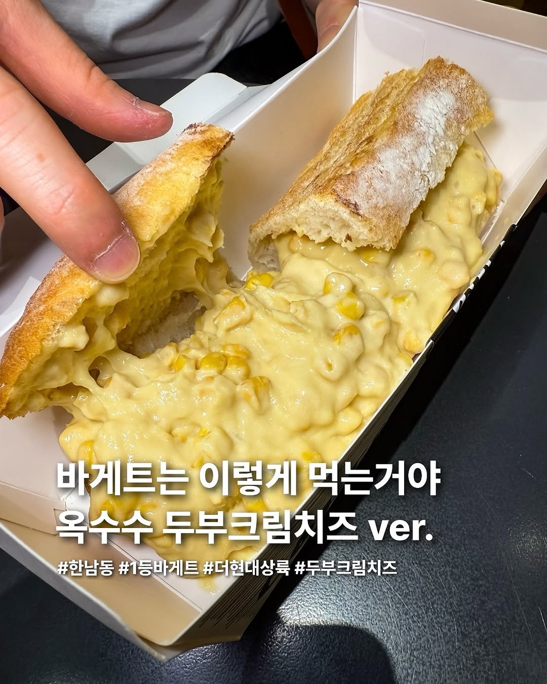Photo by 요미 | 먹스타그램 🇰🇷 on September 30, 2025. May be an image of baguette and text that says '바게트는 이렇게 먹는거야 옥수수 두부크림치즈 ver. #한남동 1등바게트 #더현대상륙 #두부크림치즈'.