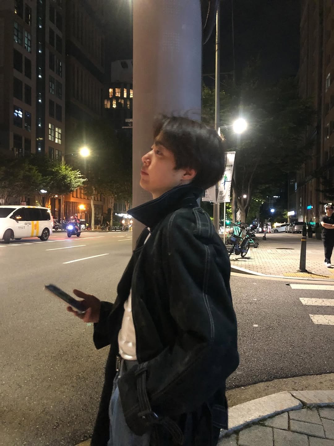 Photo shared by 조병규 on September 28, 2025 tagging @greedilous. May be an image of phone, duffle coat, overcoat, jacket, street, night and text.