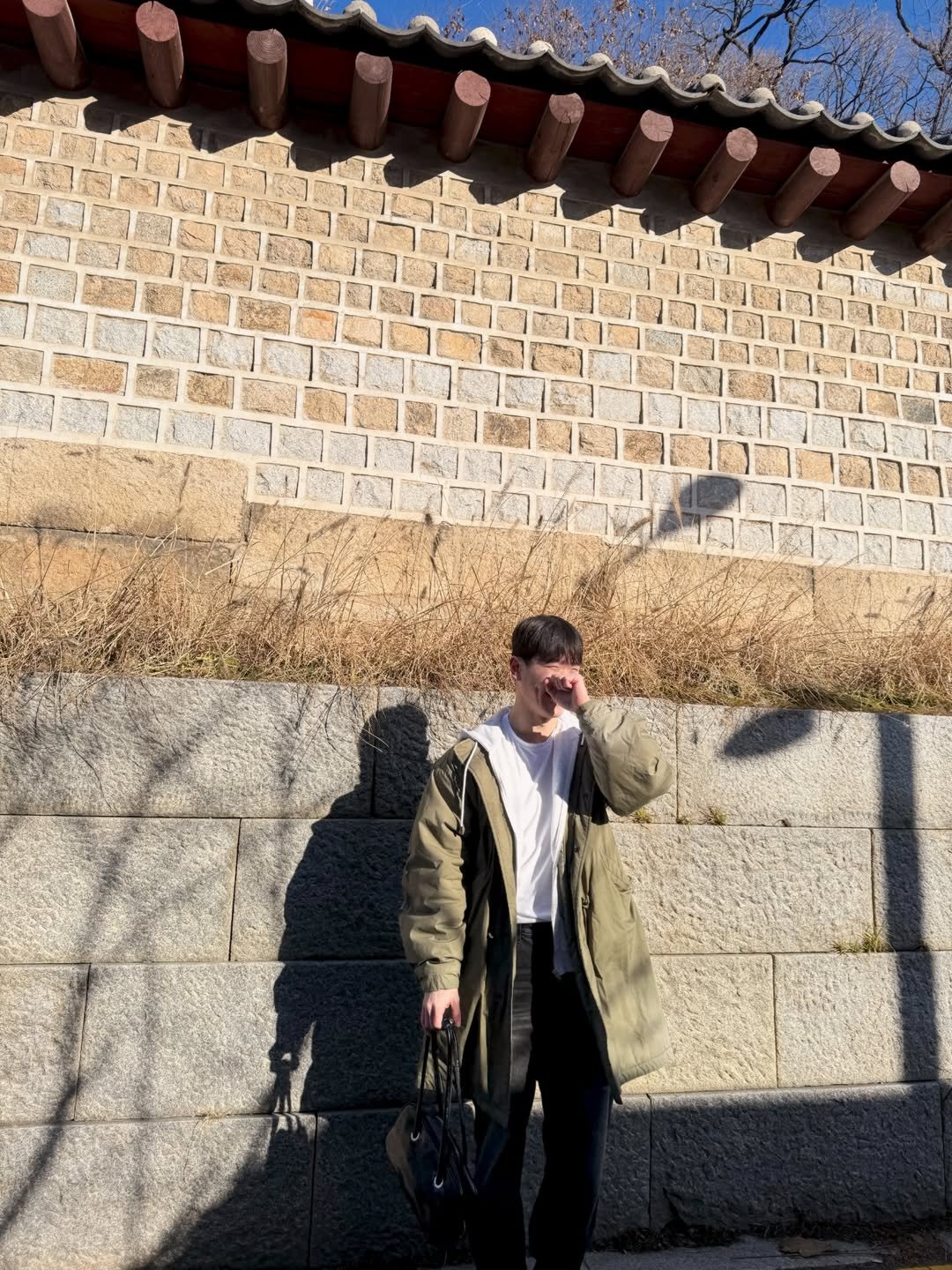 Photo by 운동하는윰점장 on December 22, 2025. May be an image of duffle coat, parka, Gyeongbokgung Palace, brick wall, the Great Wall of China and text.