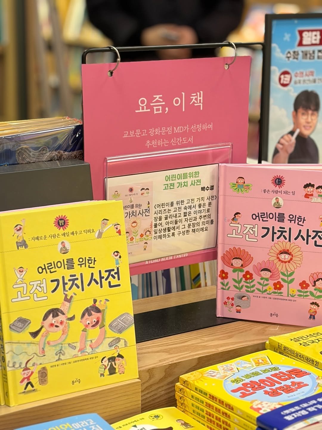 Photo by 봄 마중 on December 16, 2025. May be an image of book and text that says '일티 수확 수환경념 발념 1권 業店准： LUT 요즘, 요즘,이책 이책 교보문고 광화문점 MD가 .D가선정하여 교보문고광화문점D가선정하요 선정하여 추천하는 추천하는신간도서 신간도서 어린이들위한 고전 가치 사전 박수경 사전> 린이를위한 위한 <어린이를 위한 고전 문 가치사전 시리즈는고전 속에서 이야기로 콜라내고 자신과 풀어, 아이들이 문장의 의미를 구성한 책이에요 :좋은사람이되는일 자배로운서람은메인배우고먹어요 익해요 หามอน DANIRA 고전 어린이를 위한 가치 고전가치사 사전 고전가치사전 어린이를 위한 PD 日 불마는 we 피방송 형절과 Intees કাল 봉이주 문석의 출출효축 성인성의상구치 冷要产四 北場樂 期間 FPOE 生 a 어라코'.