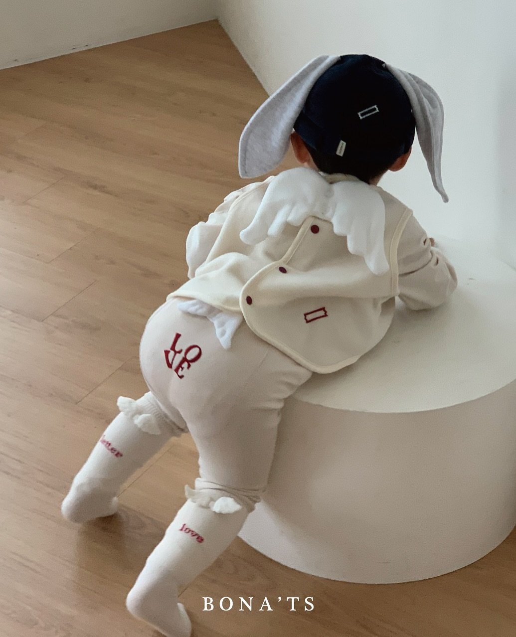 Photo by 보나츠 on September 18, 2025. May be an image of 1 person, duffle coat, toy, baby shoes and text.