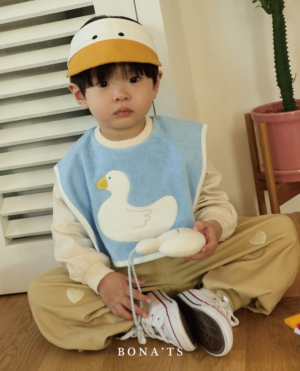 Photo by 보나츠 on December 28, 2025. May be an image of child, duck, duckling, goosedown coat, duffle coat, baby shoes and text that says 'BONA'TS'.