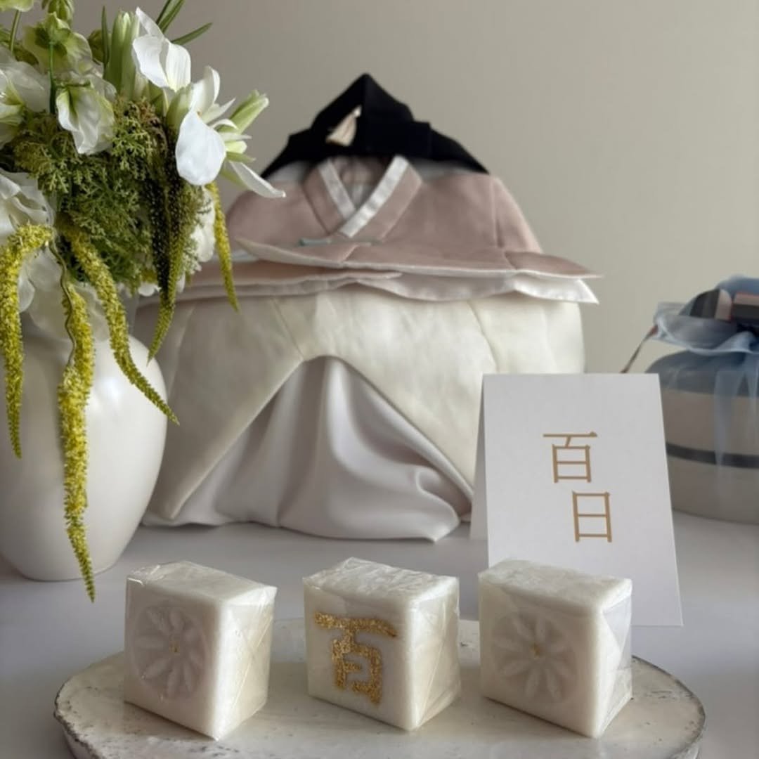 Photo by 봉앗간 | 떡케이크 | 백일떡 | 답례떡 | 클래스 on August 28, 2025. May be an image of tofu, sink, napkin ring, paper weight, bar soap, napkin, hamper, soap, hand cream, white lily and text that says '百 百 日'.