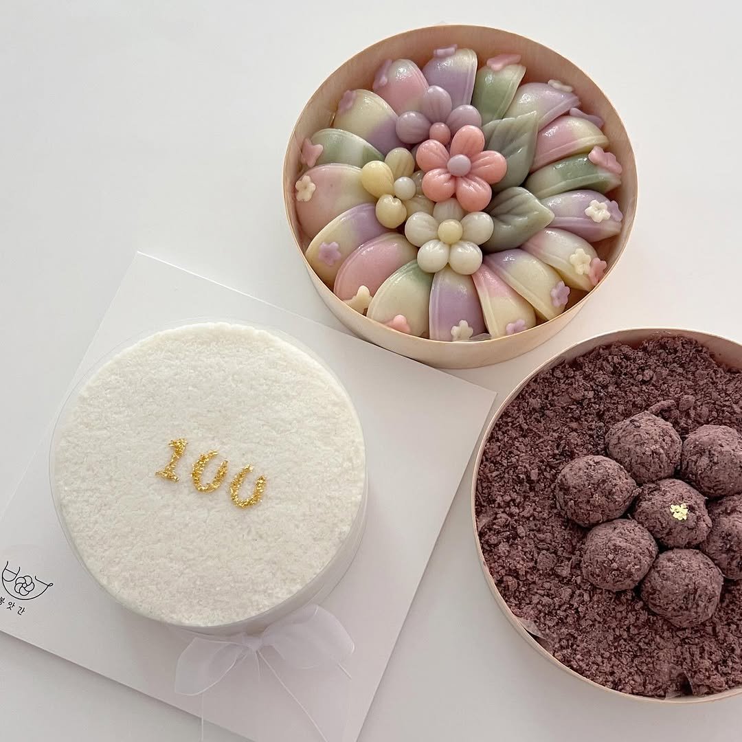 Photo by 봉앗간 | 떡케이크 | 백일떡 | 답례떡 | 클래스 on September 19, 2025. May be an image of chocolate mousse, chocolate cake, prairie gentian, globe amaranth and text that says '100 み ス'.