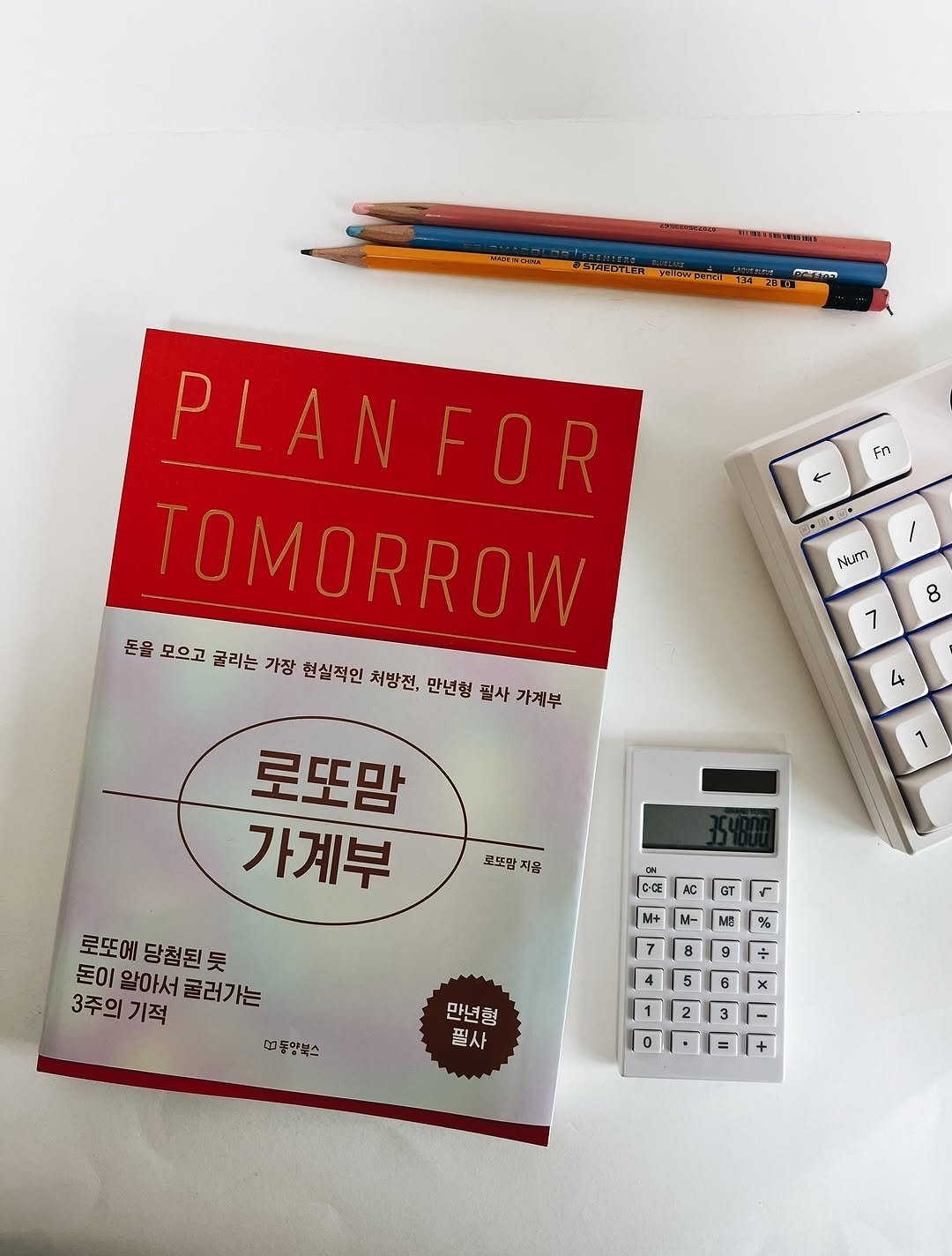 Photo shared by 봉님이의 기록, 오래걷기 on October 20, 2025 tagging @dybooks_biz. May be an image of calculator, book, ruler, crossword puzzle and text that says 'aEwparel RTe En ~ あ. NuM / PLANFOR TOMORROW 돈을 모으고 굴리는 가장 현실적인 처방전, 만년형 필사 가제부 8 7 4 로또맘 지움 로또맘 가계부 로또메당첨된듯 로또에 당첨된 돈이암아서굴러가는 듯 돈이 알아서 굴러가는 3주의 기적 AC M+ M % 8 따동양복스 6 x 만년형 필사 1 2 3 = +'.