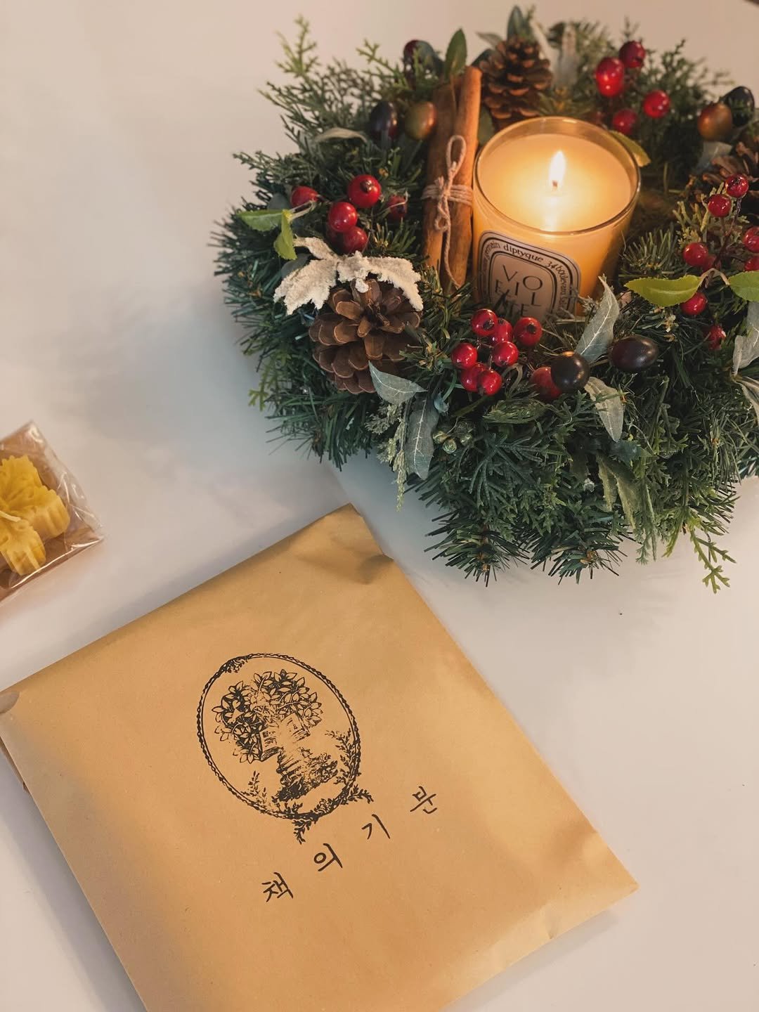 Photo by 책 의 기 분 on December 25, 2025. May be an image of placemat, napkin, hamper, candle, pinecone and text that says '책의기분 라'.
