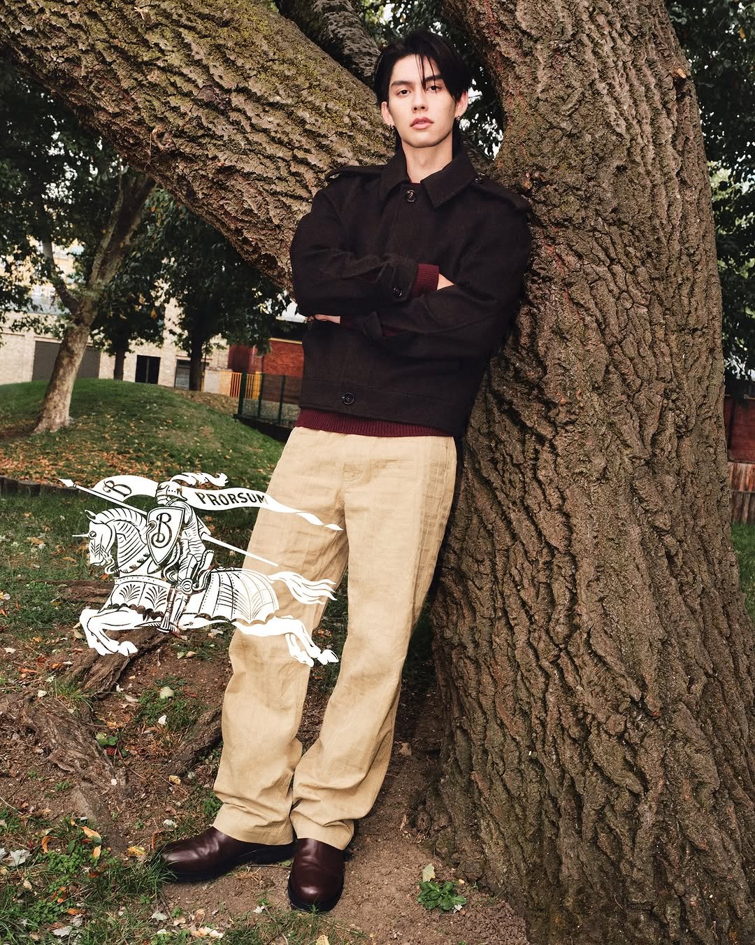 Photo shared by BRIGHT on October 14, 2025 tagging @burberry. May be an image of one or more people, bangs, duffle coat, parka, bolo tie, sweatpants, park and text that says 'PRORSUM'.