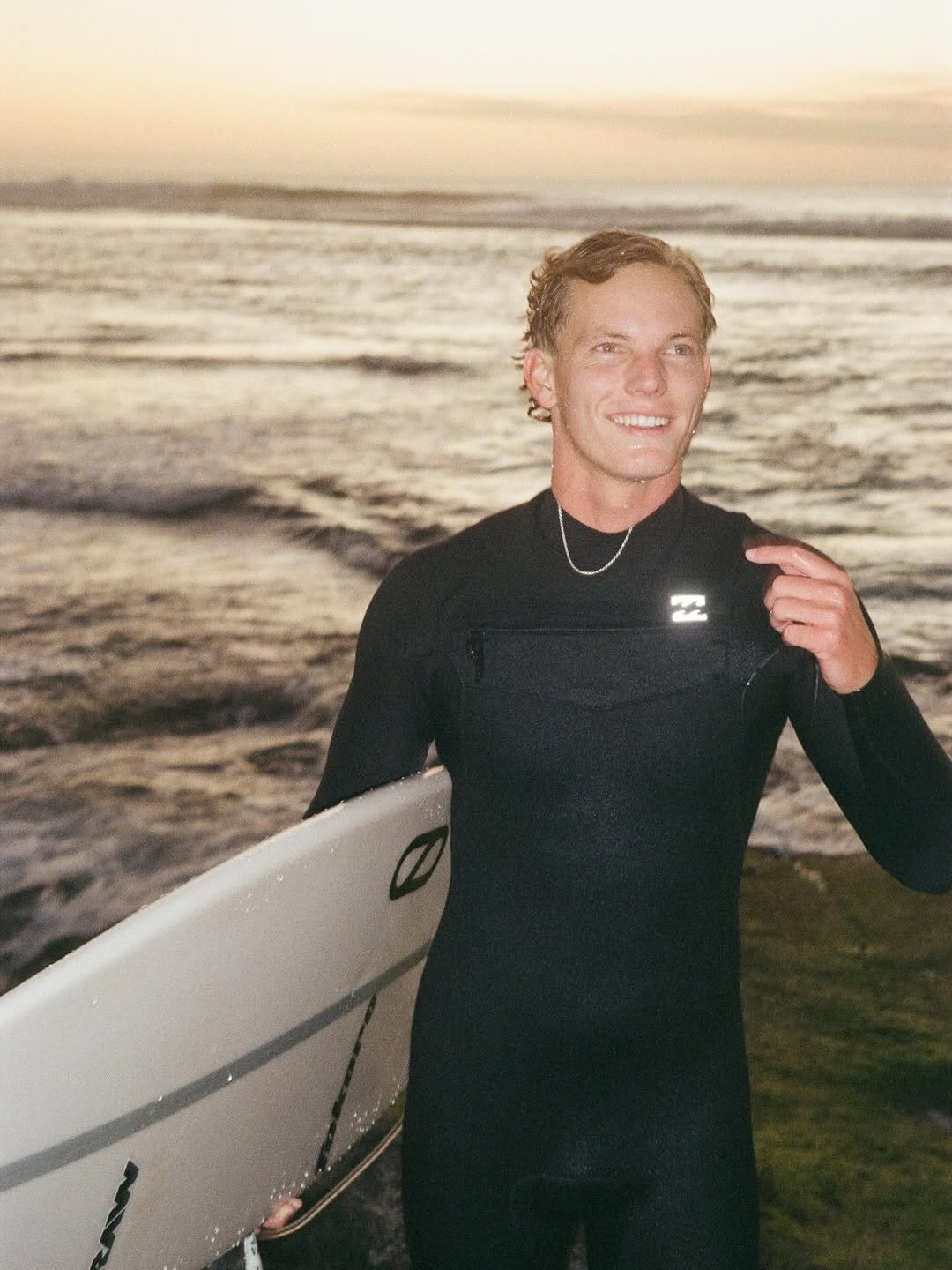 Photo by BRODI SALE on December 31, 2025. May be an image of surfboard, wetsuit, water, ocean and text.