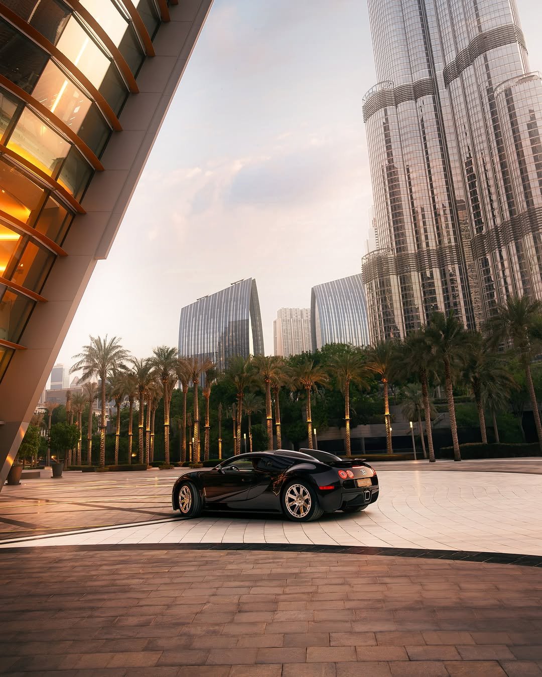 Photo shared by BUGATTI on December 21, 2025 tagging @dubaiopera, and @bugatti.uae. May be an image of car, road, skyscraper and text that says 'O9 B ሆዱ'.