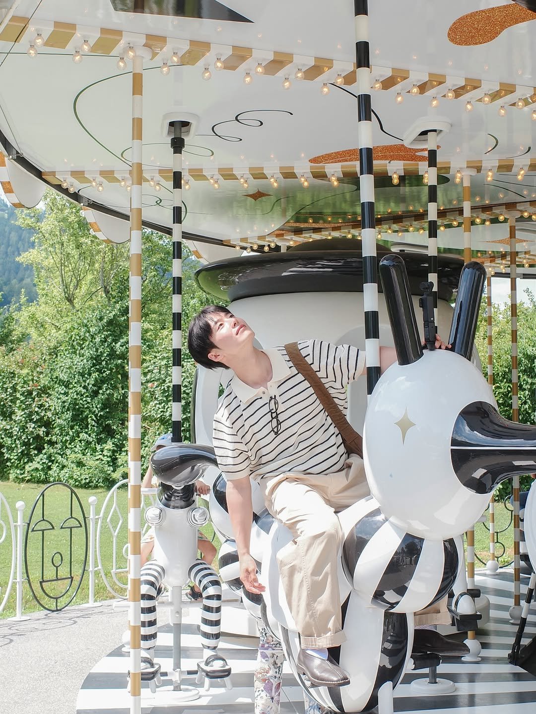 Photo shared by 조잽미 on July 13, 2025 tagging @innsbrucktourism, @swarovski, and @visitaustria. May be an image of 1 person, stripes, riding a crousel and text.