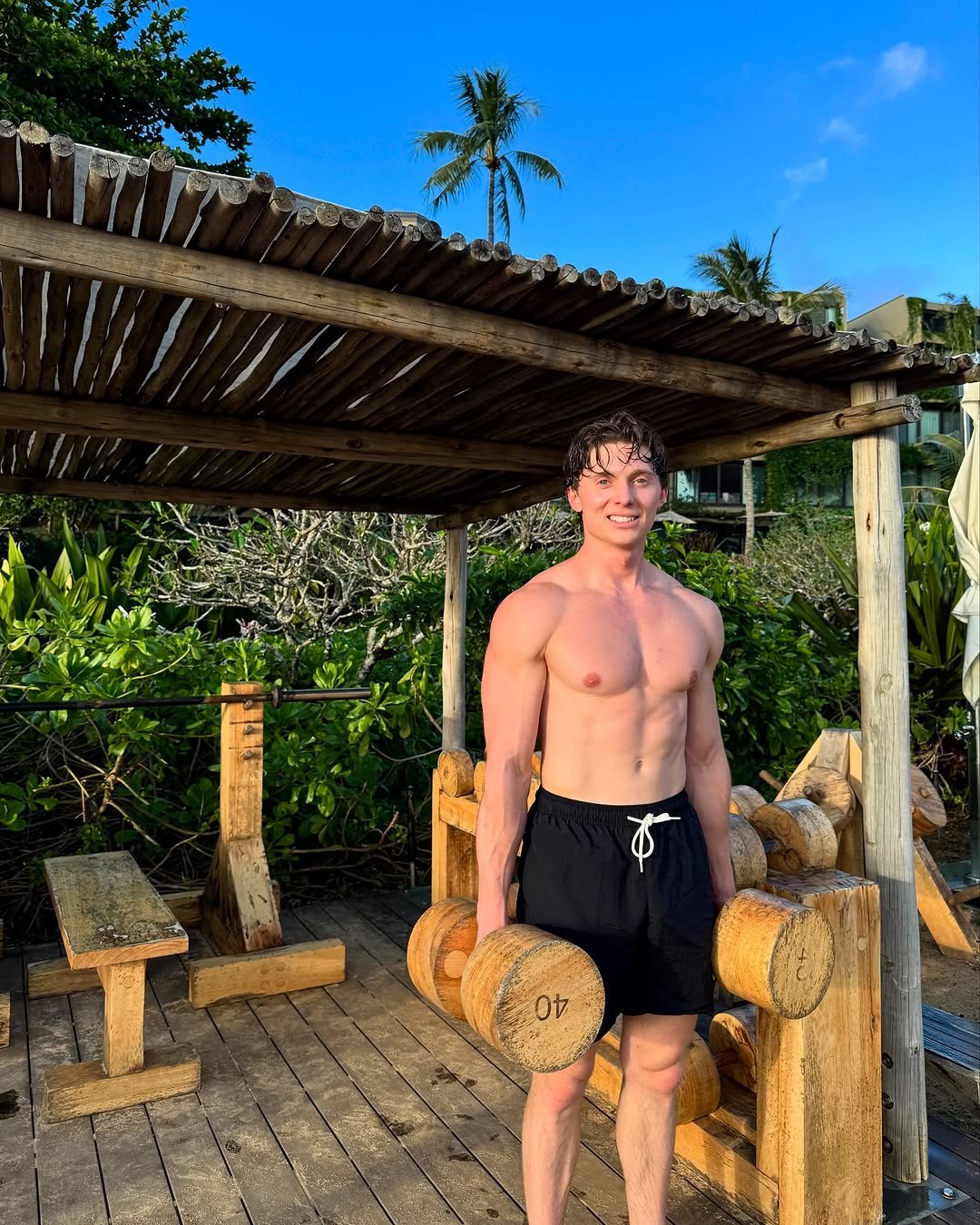 Photo by Brandon William on March 26, 2025. May be an image of one or more people, biceps, sarong, bamboo, beach and text.