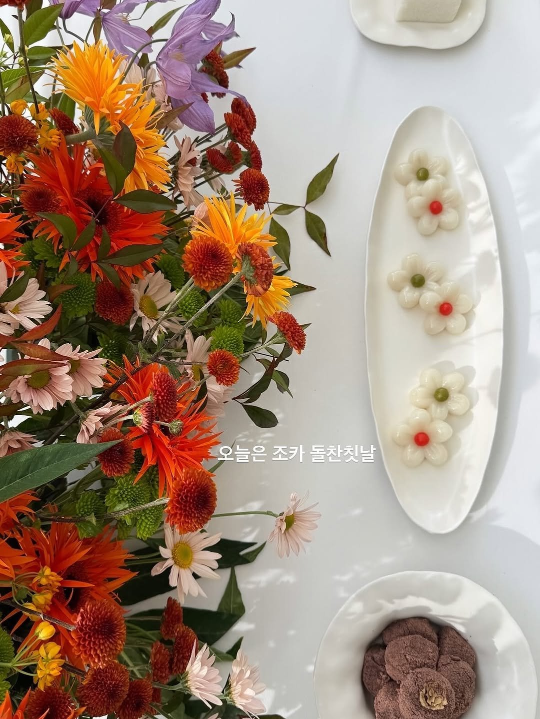 Photo by 바이율 | 박진경 on November 15, 2025. May be an image of placemat, flower arrangement, globe amaranth, carnation and text that says '오늘은 조카 돌찬칫날'.