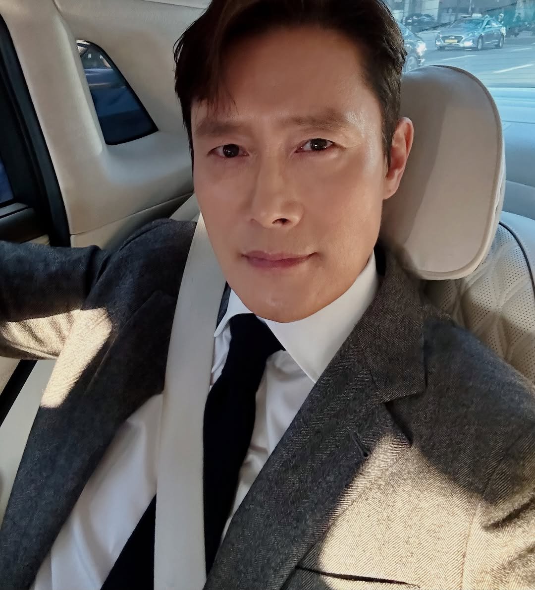 Photo by LeeByungHun 이병헌 on October 23, 2025. May be a selfie of one or more people, overcoat, suit, blazer, dinner jacket, turtleneck and text.