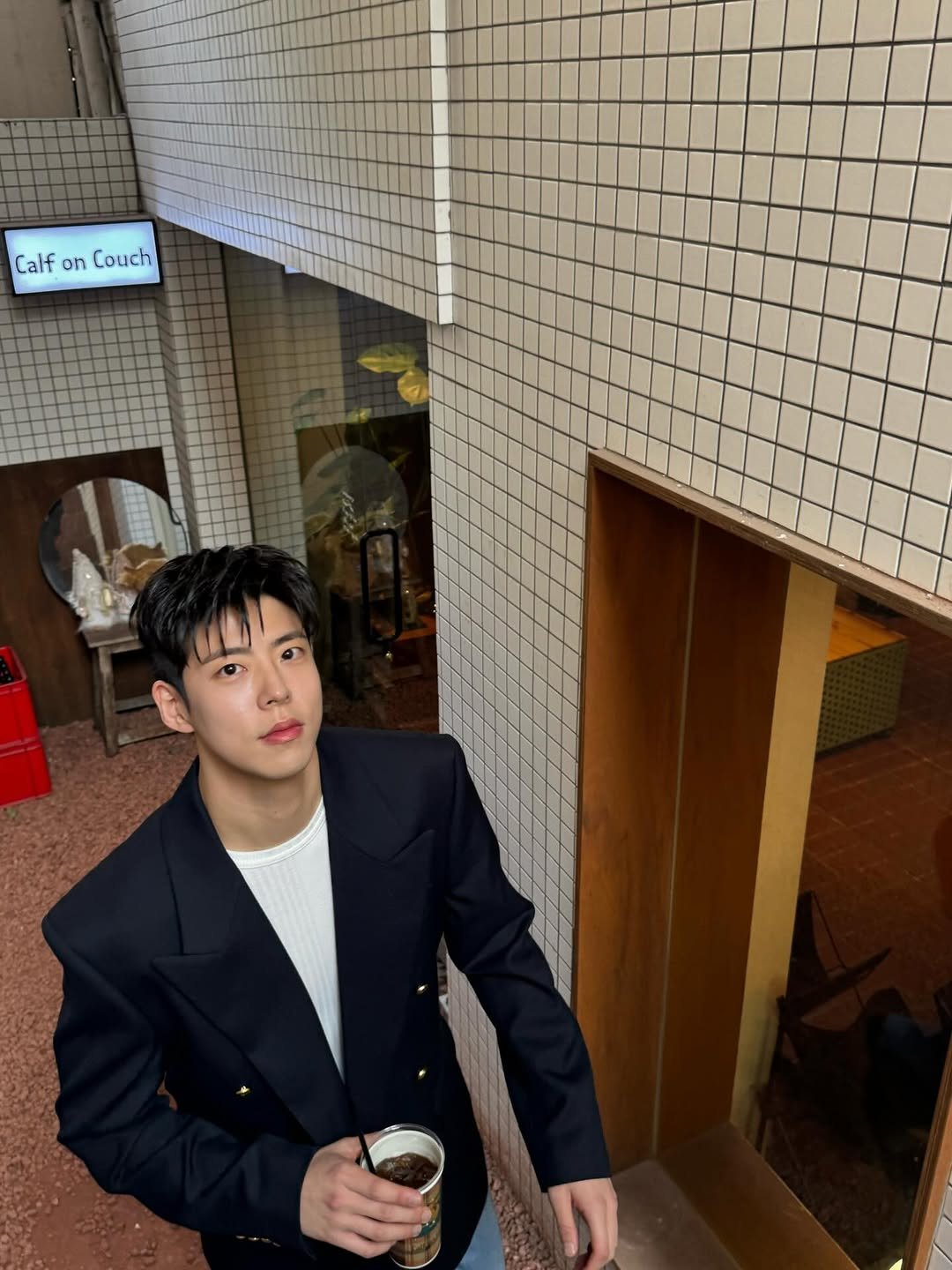 Photo by 최우성 on January 20, 2026. May be an image of one or more people, wingtip shoes, duffle coat, dinner jacket, suit, blazer, bolo tie, cornflower and text that says 'Calf on Couch 行'.