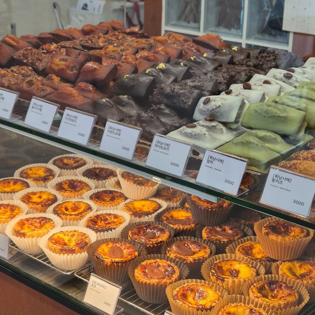 Photo by 마운드 : 휘낭시에, 에그타르트 가게 | 단체주문 전문 in 수원시. May be an image of muffin, brownie, pastry, fudge, display case and text.