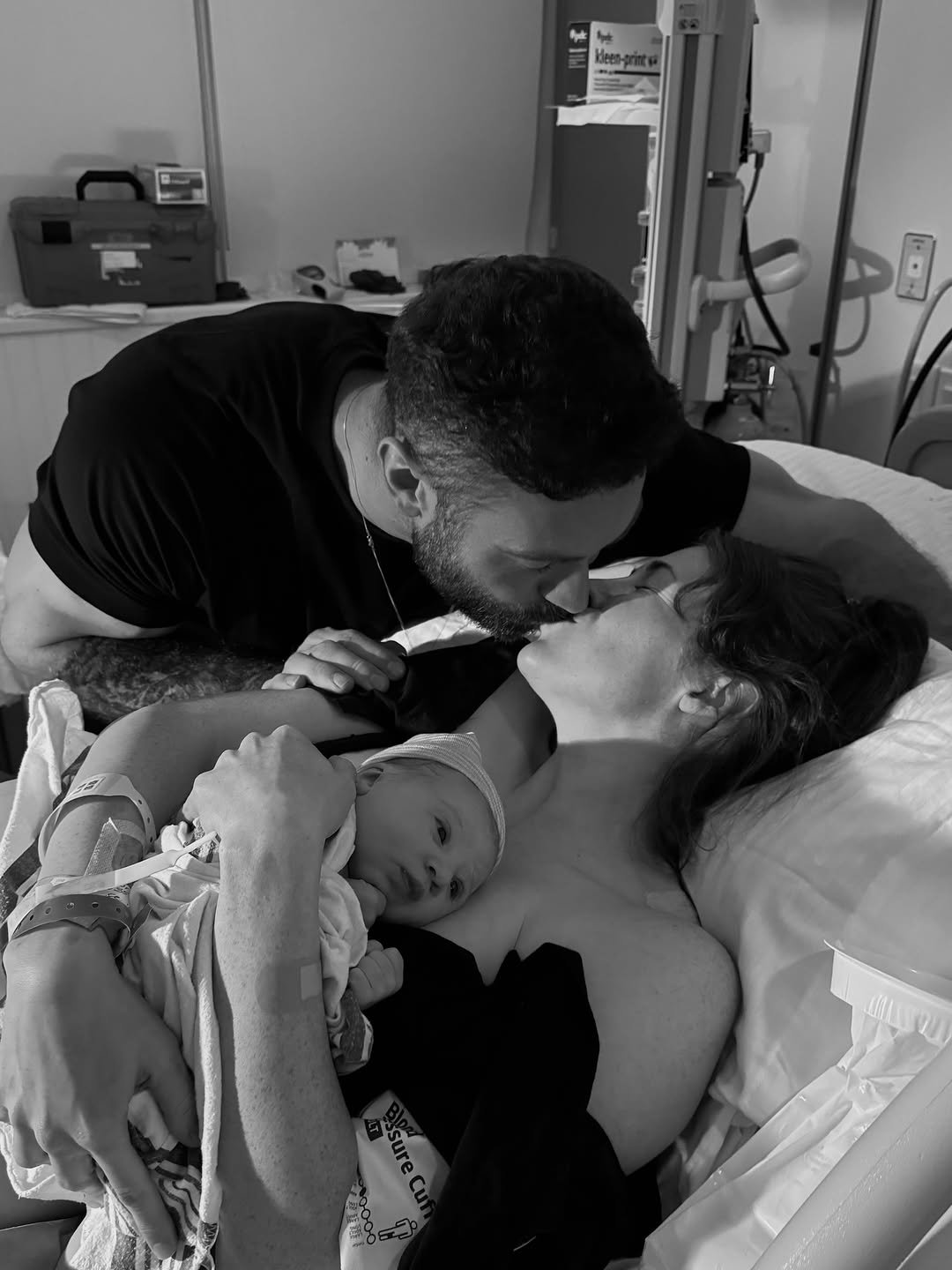 Photo shared by Chris Bumstead on January 15, 2026 tagging @courtneykiing. May be a black-and-white image of baby, people kissing, hospital and text.