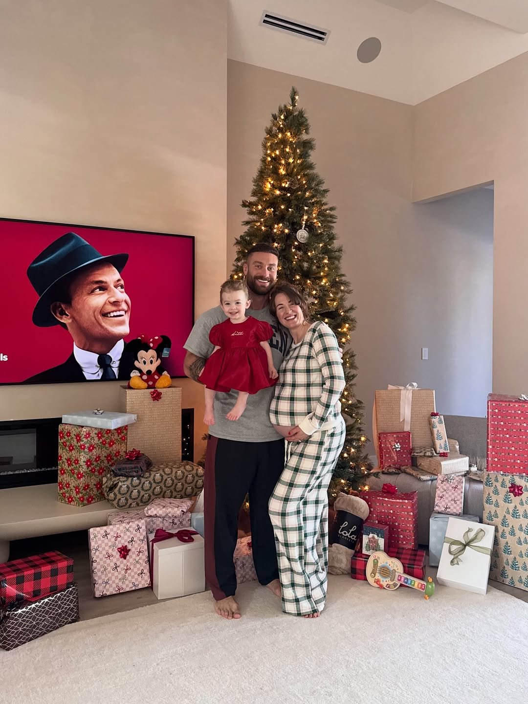 Photo shared by Chris Bumstead on December 27, 2025 tagging @courtneykiing. May be an image of christmas tree, flannel, bath robe, tinsel and text.