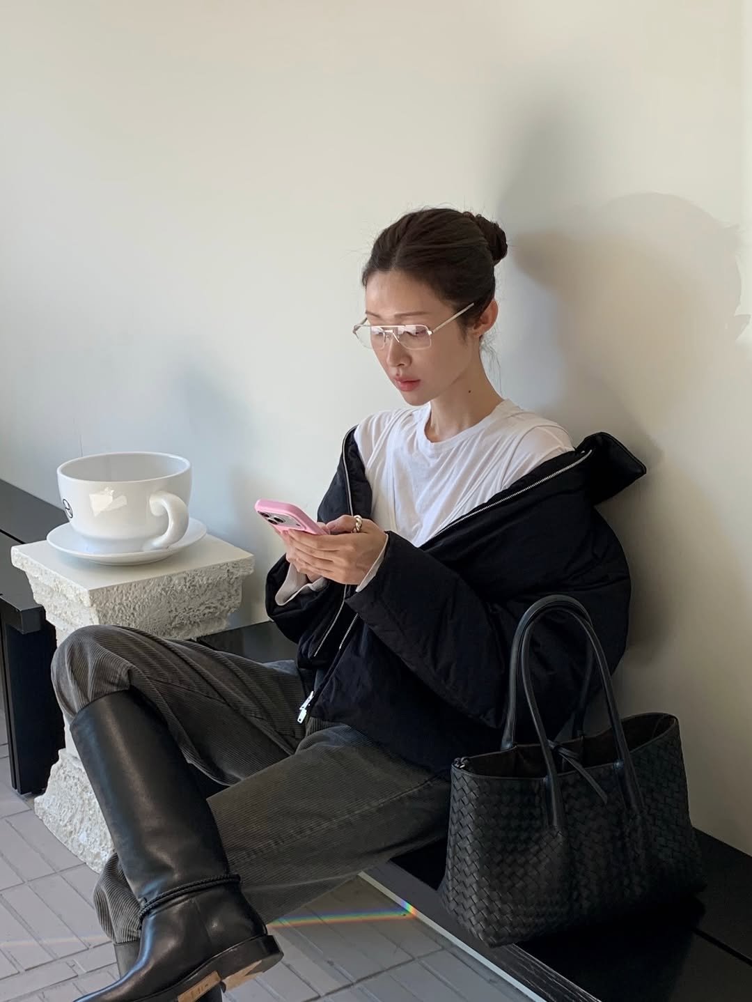 Photo shared by 차정원 on December 22, 2025 tagging @newbottega. May be an image of phone, duffle coat, overcoat, boots, turtleneck, cornflower and text.