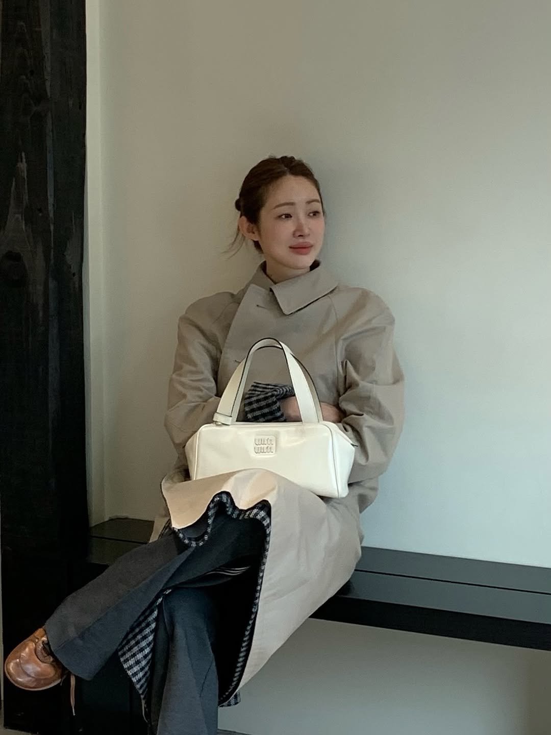 Photo shared by 차정원 on September 25, 2025 tagging @miumiu. May be an image of 1 person, overcoat, duffle coat, purse, cornflower and text.