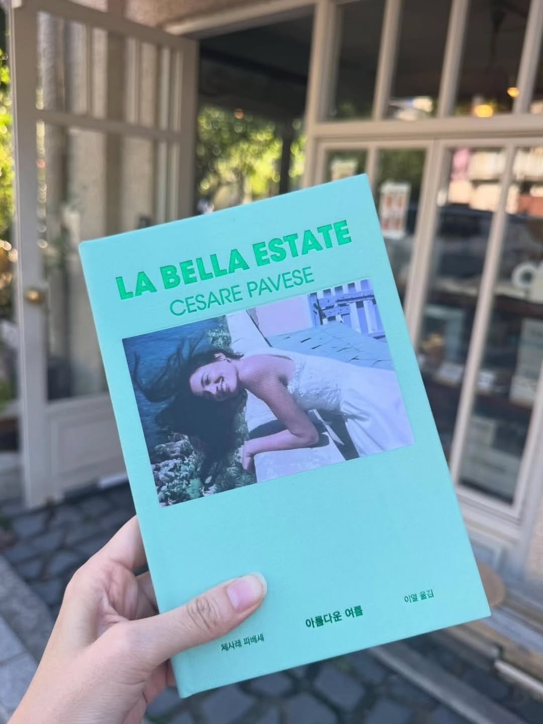 Photo by 책방 연희 chaegbangyeonhui on September 22, 2025. May be an image of 2 people, magazine, book, cornflower and text that says 'LA BELLA ESTATE CESARE PAVESE 이멀을김 이밀 옮김 아름다운 아름다운여를 운 여름 제시래피배세 체사레, 파에세'.