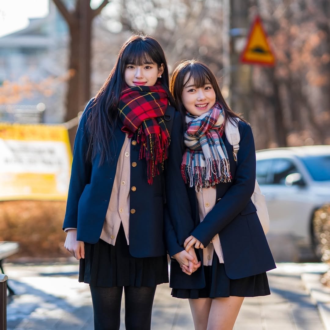 Photo shared by CheezeFilm on January 22, 2026 tagging @1o._.z3, and @suahmuah. May be an image of one or more people, duffle coat, scarf, miniskirt, parka, outdoors and text.