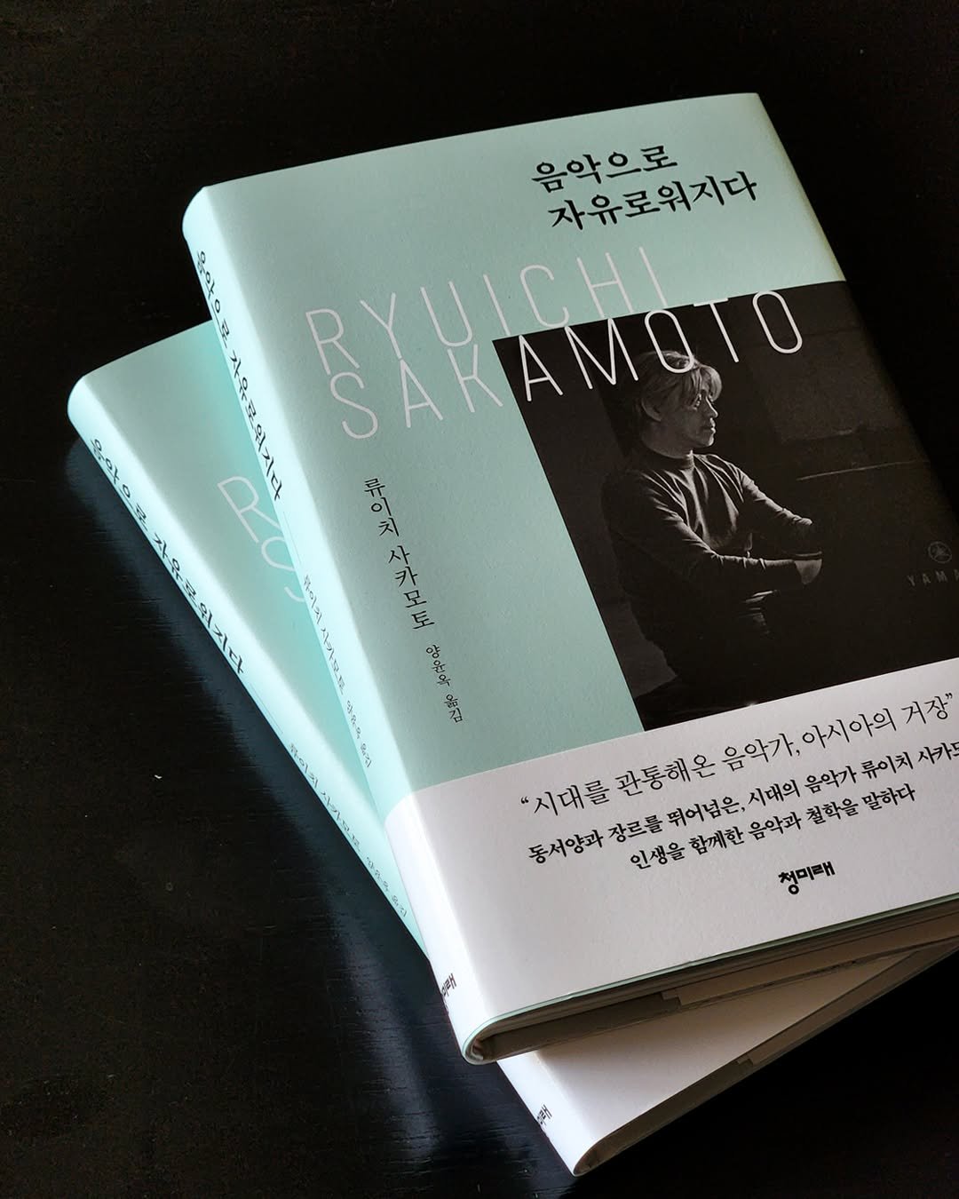 Photo by 도서출판 청미래 on September 18, 2025. May be an image of 1 person, book, magazine and text that says '음악으로 자유로워지다 sats a 비로 gat 있지다 EXAMgIO RYUICHIN SC 휴이치 받으치사카모로 사카모로 자유문워지다 et አንደር &지 거장" "시대를 "시대를관통해온 관통해온 음악가,아시아의거장 음악가, 아시아의 류이치 사카드 동서양과 장르를뛰어넘은,시대의 장르를 인생을함께한음악과 뛰어넘은, 시대의 음악가 인생을 함께한 음악과 철학을 말하다 청미래 森 路'.