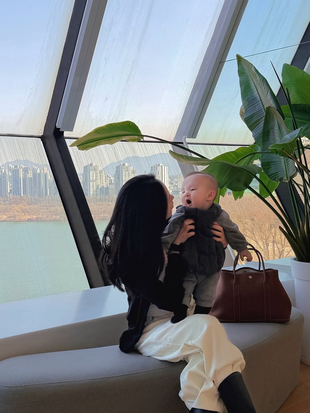 Photo by 유치치 on March 09, 2026. May be an image of baby, people kissing, sling and text.