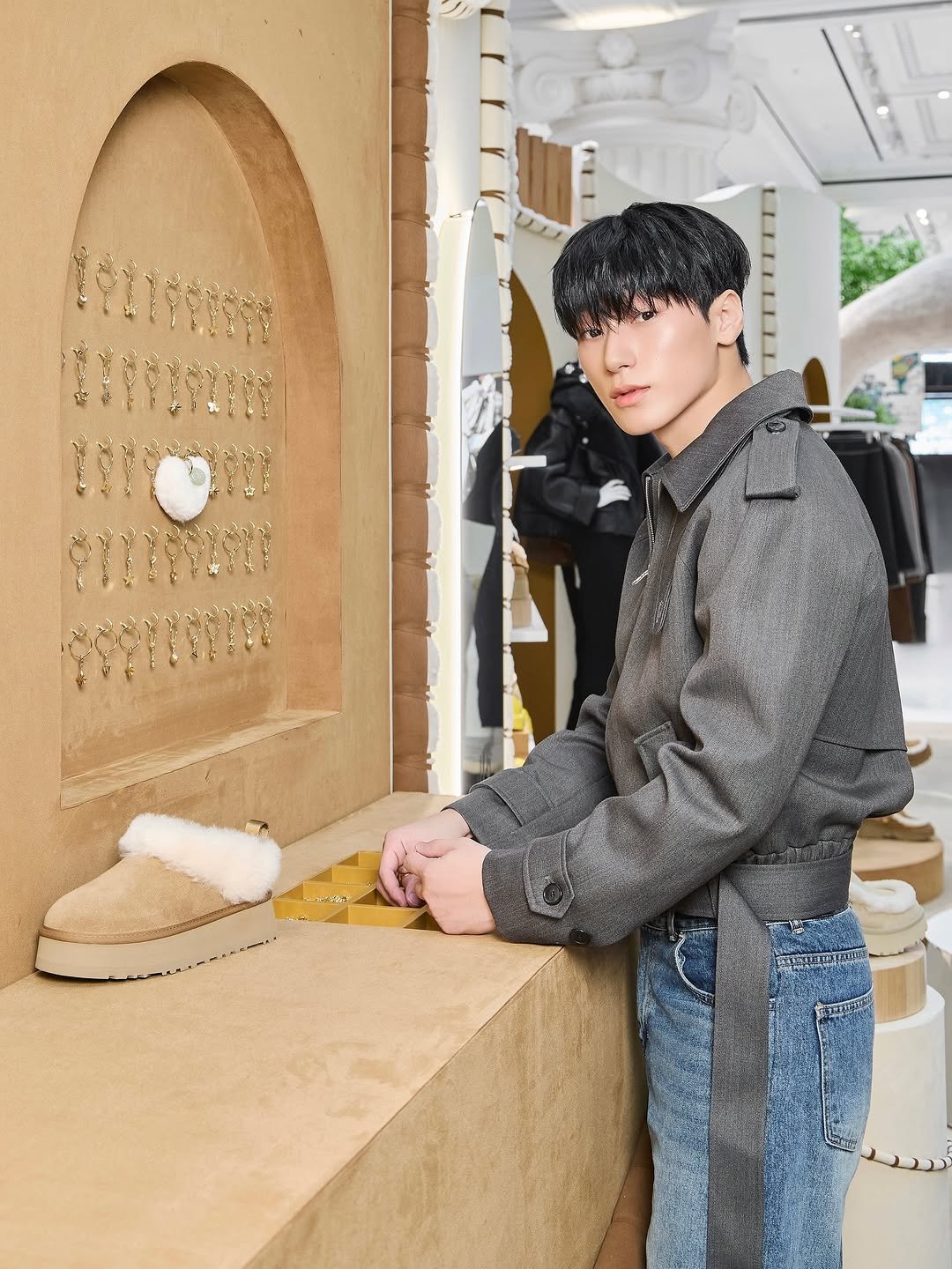 Photo shared by 산 (SAN) on October 02, 2025 tagging @ugg_korea. May be an image of 1 person, duffle coat, goosedown coat, boots, bolo tie and text.