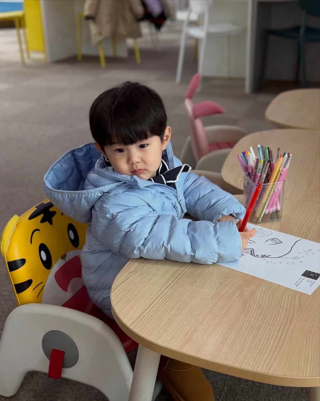 Photo by 이츄맘💖 on January 24, 2026. May be an image of baby, studying, duffle coat, goosedown coat, raincoat, parka, chopsticks and text.