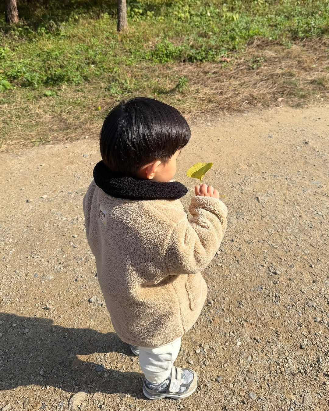 Photo by 이츄맘💖 on November 12, 2025. May be an image of child, duffle coat, outdoors and text.