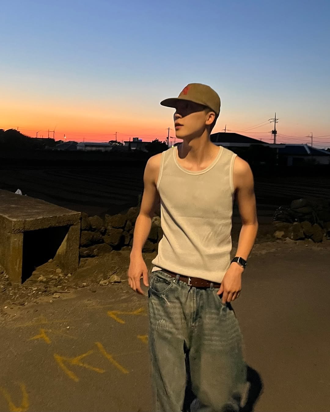 Photo by 김정철 on July 04, 2025. May be an image of 1 person, standing, tanktop, twilight, outdoors and text.