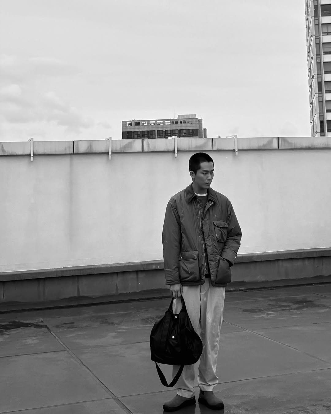 Photo by 김정철 on October 26, 2025. May be a black-and-white image of standing, wingtip shoes, overcoat, parka, street and text.