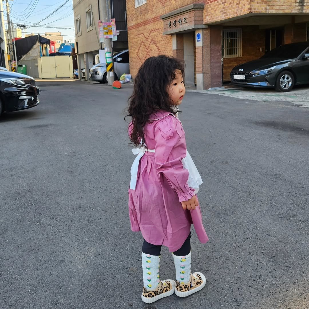 Photo by 혜진 on February 17, 2026. May be an image of baby, duffle coat, overcoat, sleepwear, robe, bath robe, boots, cardigan, raincoat and text.