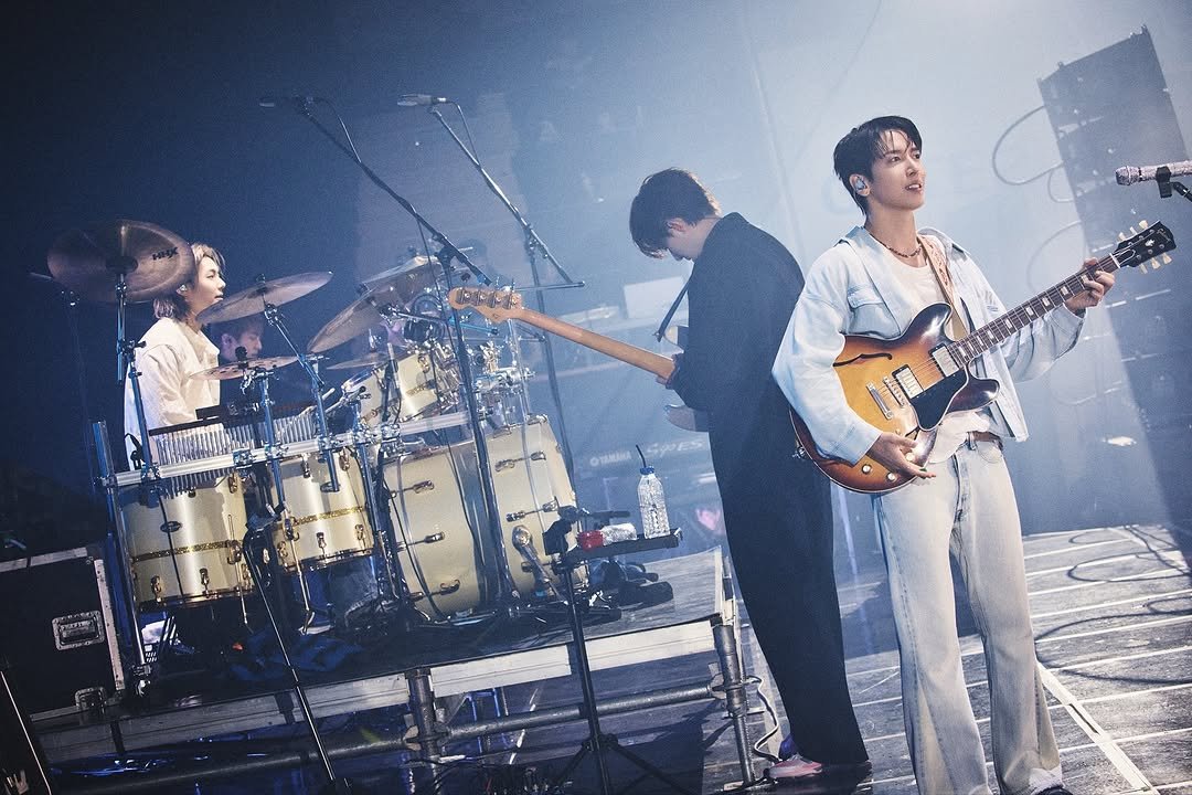 Photo shared by CNBLUE OFFICIAL on November 20, 2025 tagging @mr_kanggun, @leejungshin91, and @jyheffect0622. May be an image of guitar, tambourine, drum, concert and text.