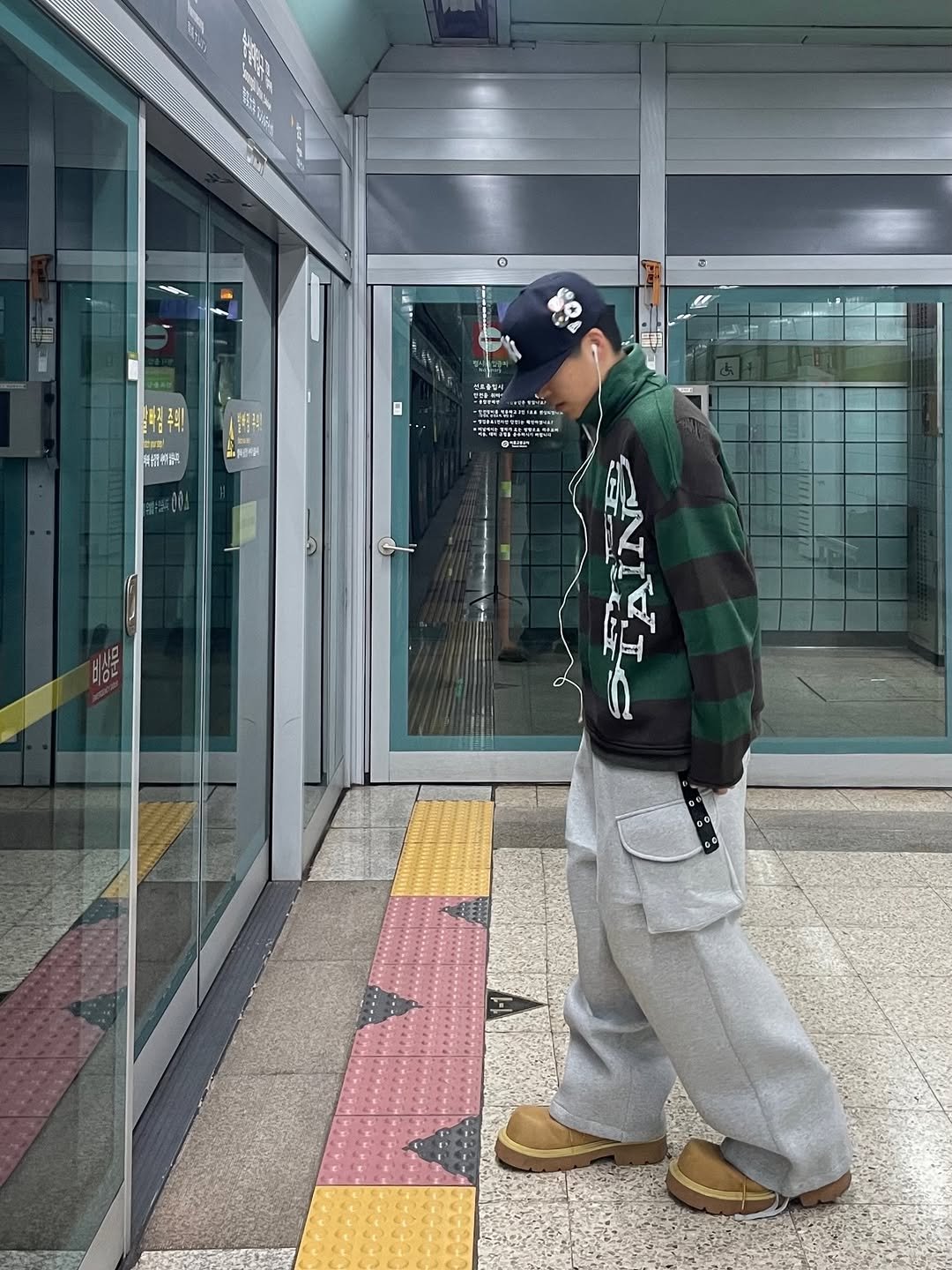 Photo by 정인 on December 31, 2025. May be an image of standing, turnstile, duffle coat, face mask, parka, sweatpants, street and text.