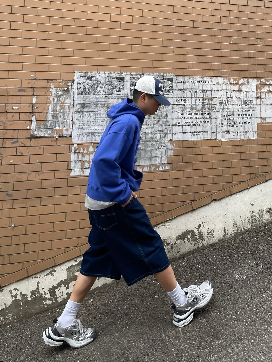 Photo shared by 정인 on April 09, 2026 tagging @philippakerlab. May be an image of duffle coat, sweatpants, sportswear, brick wall and text.