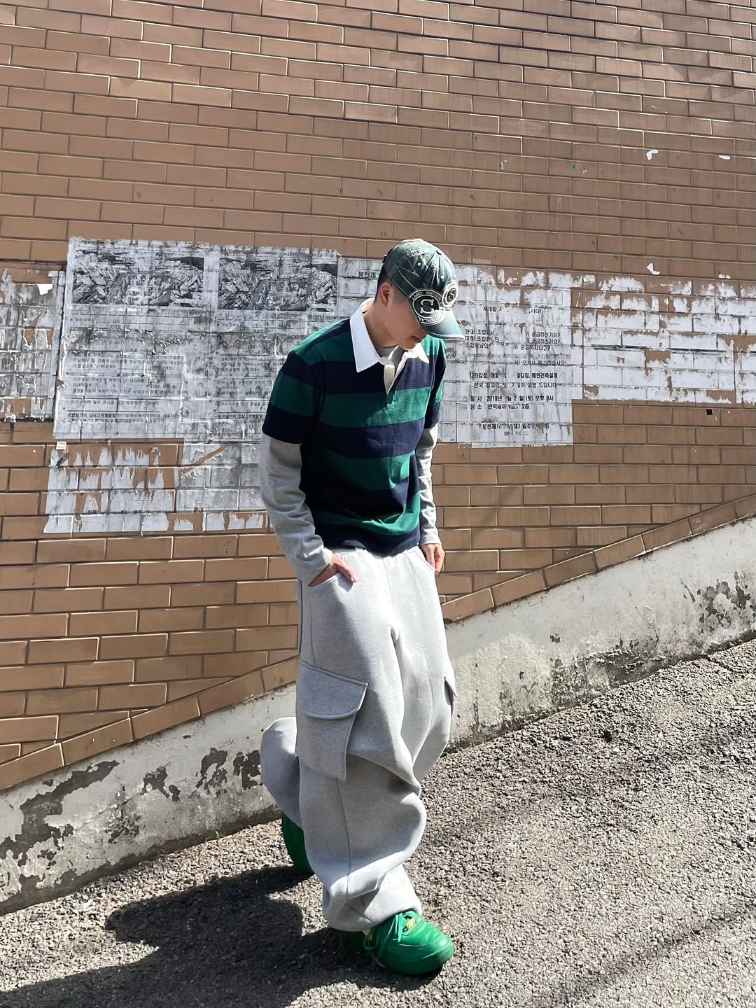 Photo shared by 정인 on April 25, 2026 tagging @takeasy_official. May be an image of wingtip shoes, beret, sweatpants, kilt, brick wall and text.