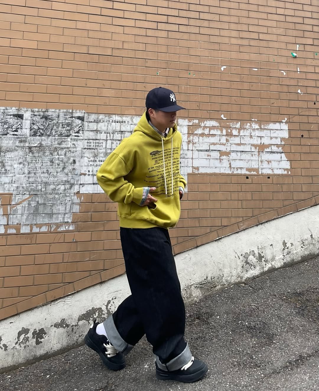Photo shared by 정인 on April 07, 2026 tagging @lofi_official_. May be an image of duffle coat, wingtip shoes, sweatpants, parka, street, brick wall and text.
