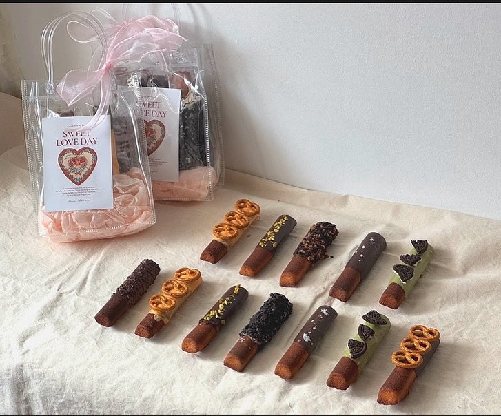 Photo by 화성답례품| 쌀디저트 | 통밀디저트 | 향남과자상점 on October 24, 2025. May be an image of ‎chocolate bar, breadstick, popcorn, pretzel, fudge and ‎text that says '‎EVEET ONEDAY ONT DAY جاج SWEEİ LOVEDAY EeL LOVEDAY LOVE DAY emes 新所 - 680‎'‎‎.