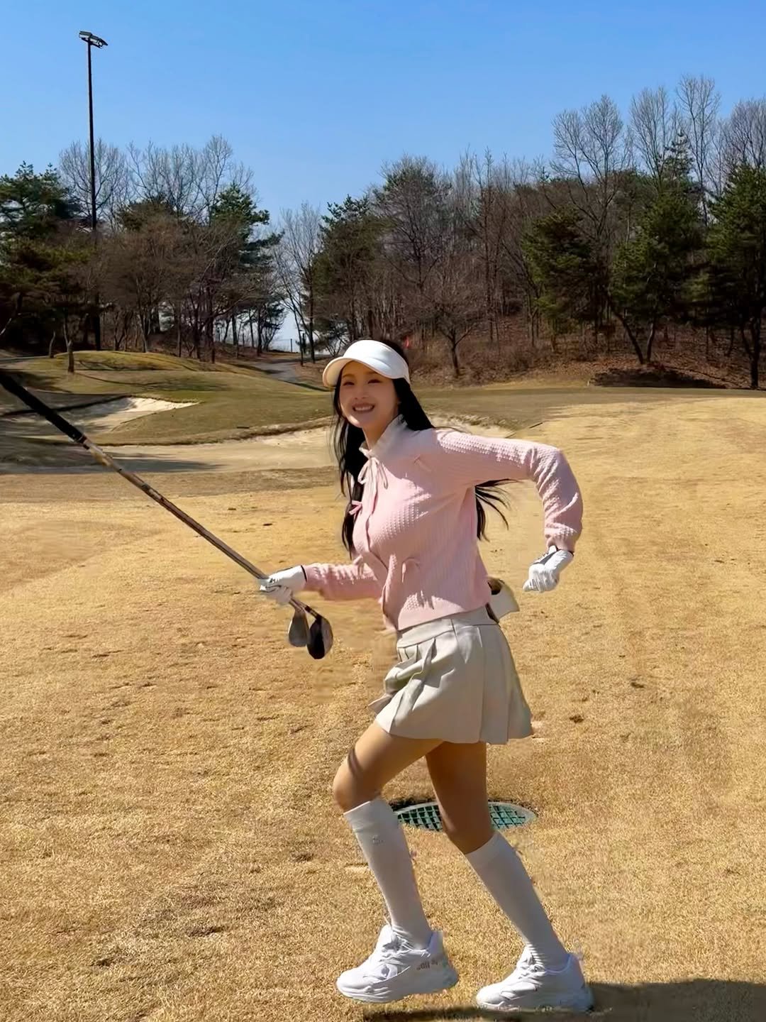 Photo shared by 💗큐트셔니 on April 02, 2026 tagging @fairliar_official. May be an image of golf, golf club, miniskirt, golf course and text.