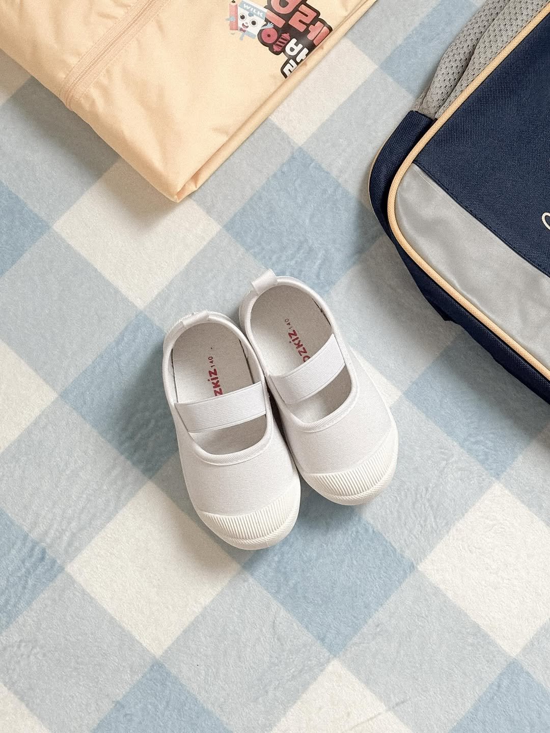Photo shared by 홍다애 on August 19, 2025 tagging @ozkiz_official. May be an image of suitcase, welcome mat, wingtip shoes, baby shoes, placemat, carpet, diaper, checker board and text.